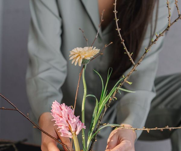Person meditating peacefully in a sunlit room with plants.